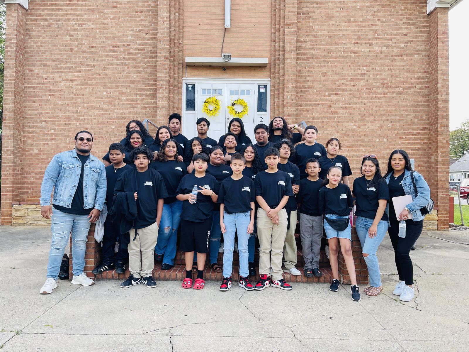 Grupo de jóvenes de la iglesia frente al edificio